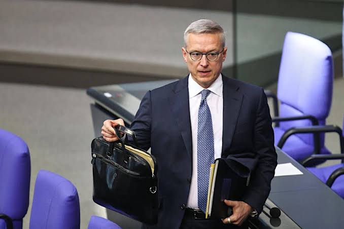 Karsten Wildberger with a briefcase and folders in the Bundestag plenary chamber